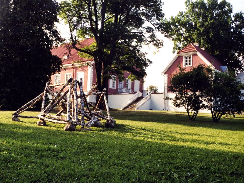 <b><i>Driehoekvariant</i></b>, 2002, berkenhout zwerfkeien, 300x300x150 cm, Sagadi (Estonia)